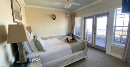 A queen bed in a coastal hotel suite with ocean views