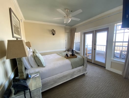 A queen bed in a coastal hotel suite with ocean views