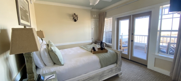 A queen bed in a coastal hotel suite with ocean views