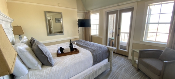 A cozy coastal hotel suite with a Juliet balcony
