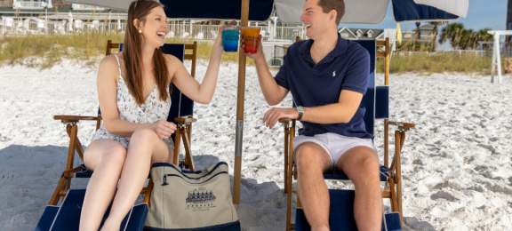 couple toasting drinks on beach