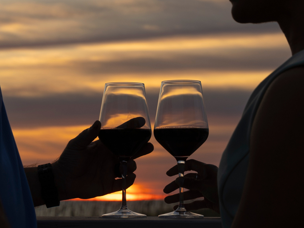 Couple toasting their wine glasses during sunset